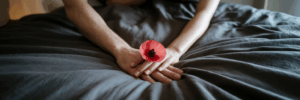 Couple's hands holding a red petal